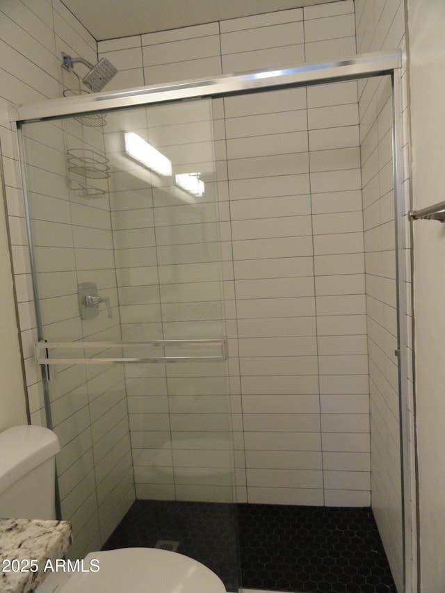 full bath with toilet and a stall shower