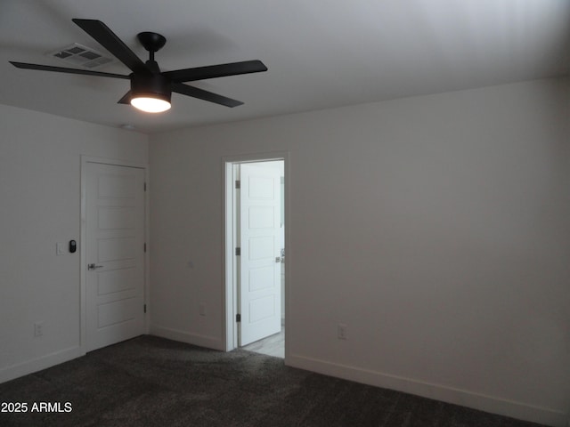 carpeted spare room featuring a ceiling fan and baseboards