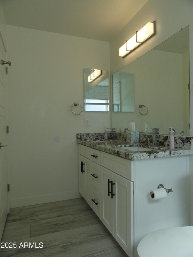 bathroom with vanity, baseboards, and toilet