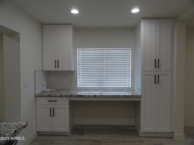 kitchen with white cabinets, light wood-style floors, light stone countertops, recessed lighting, and tasteful backsplash