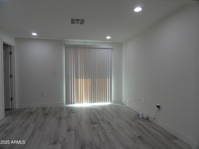 unfurnished room with recessed lighting, wood finished floors, and baseboards