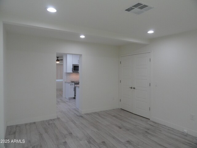 unfurnished room with recessed lighting, light wood-style flooring, and baseboards