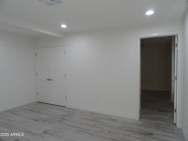 empty room with recessed lighting, light wood finished floors, and baseboards
