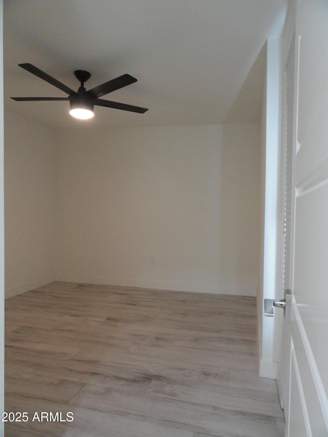 spare room with a ceiling fan and light wood-style flooring