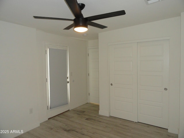 unfurnished bedroom with light wood finished floors, a closet, and ceiling fan