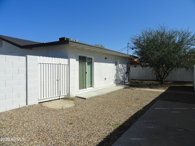 back of property featuring fence and stucco siding