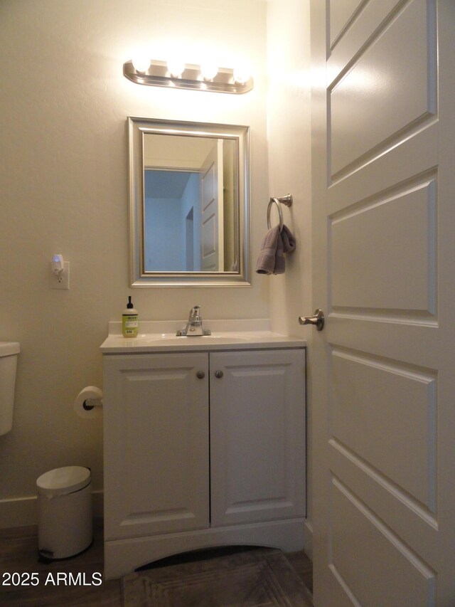 half bath featuring vanity and toilet
