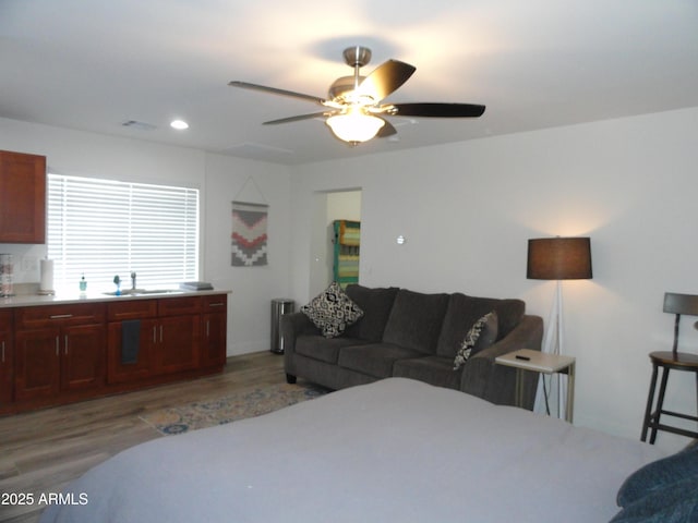living area with ceiling fan, light wood-style flooring, and recessed lighting