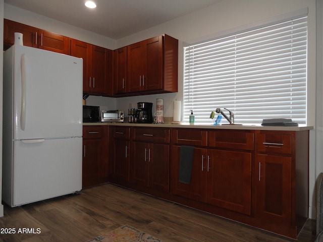 kitchen featuring freestanding refrigerator, dark wood finished floors, light countertops, a sink, and recessed lighting