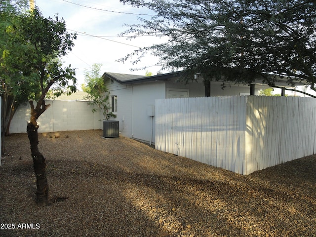 view of side of home featuring central air condition unit and fence