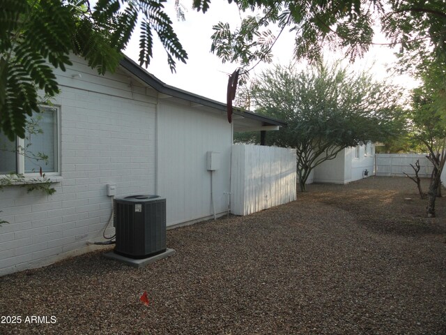 view of home's exterior featuring central air condition unit and fence