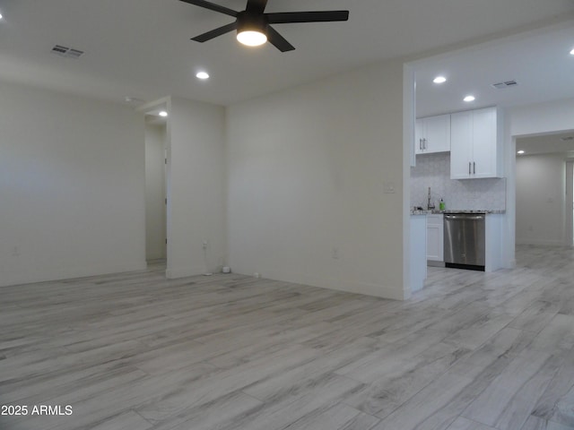 unfurnished living room featuring a ceiling fan, light wood-style floors, recessed lighting, and a sink