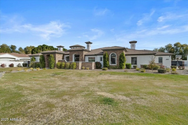 mediterranean / spanish house featuring a front lawn