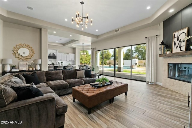 living room with a chandelier and a large fireplace