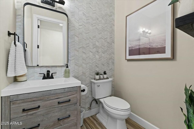 bathroom featuring hardwood / wood-style flooring, toilet, and vanity