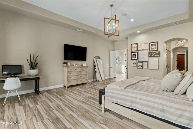 bedroom featuring light wood-type flooring and a chandelier