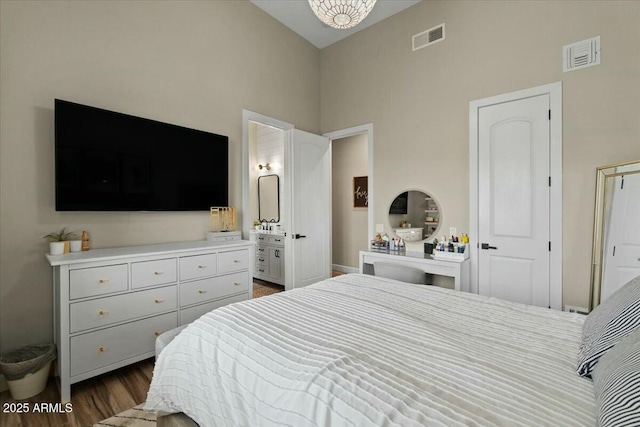 bedroom featuring dark wood-type flooring, connected bathroom, and lofted ceiling