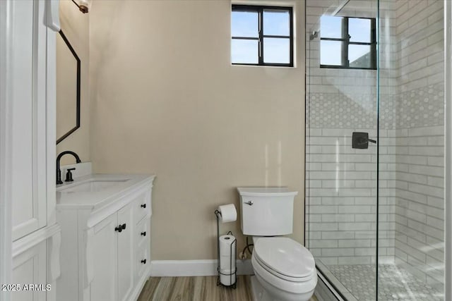 bathroom with wood-type flooring, an enclosed shower, vanity, and toilet