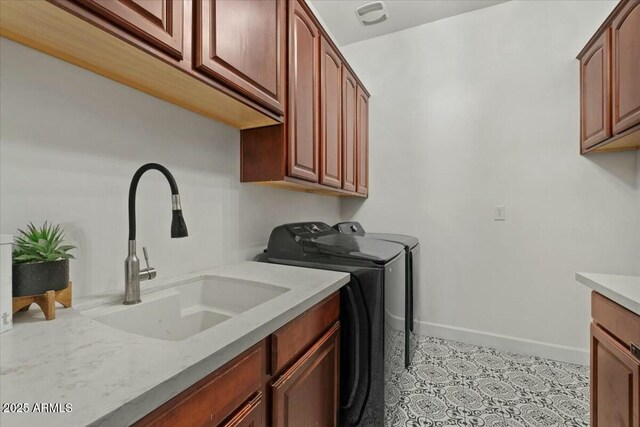 clothes washing area featuring sink, cabinets, and washing machine and dryer