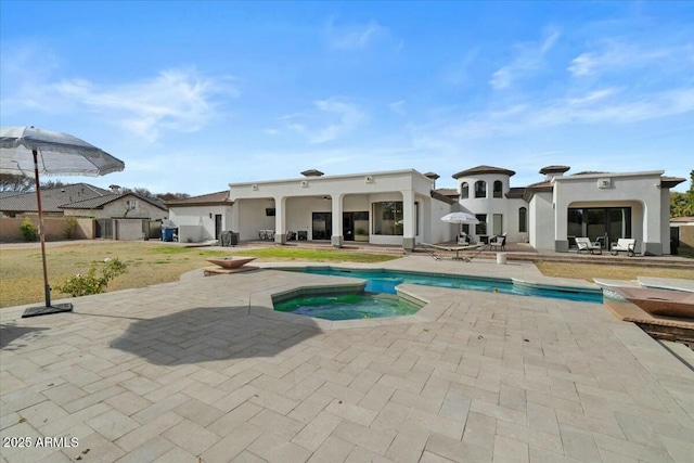 view of swimming pool featuring a patio area and an in ground hot tub