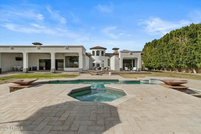 back of house featuring a pool with hot tub and a patio area