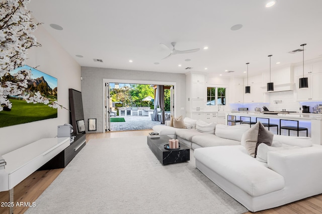 living room featuring ceiling fan and light wood-type flooring