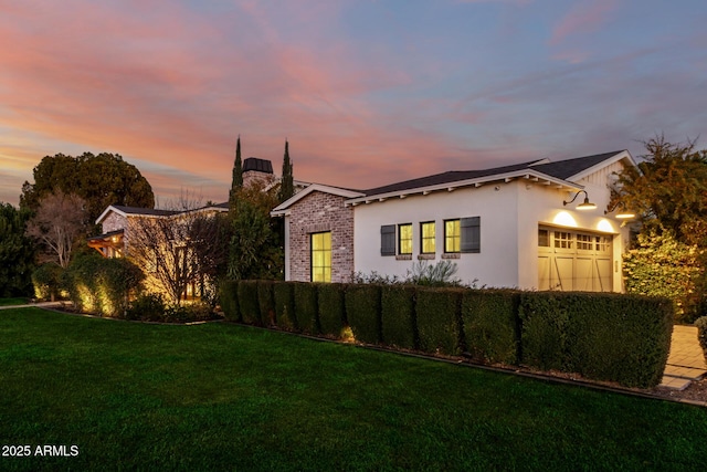 property exterior at dusk with a yard and a garage