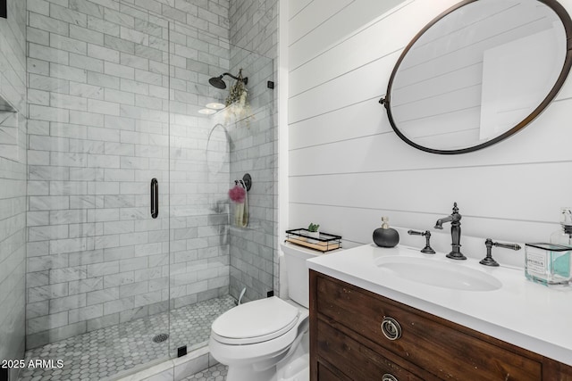 bathroom featuring a shower with door, vanity, and toilet