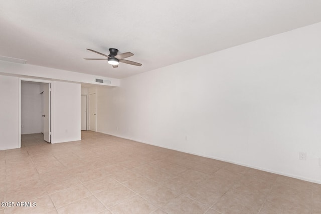 spare room with a ceiling fan, visible vents, and light tile patterned floors