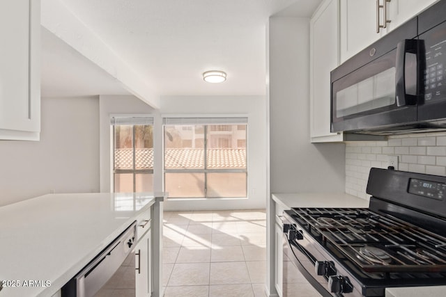 kitchen featuring decorative backsplash, white cabinetry, black appliances, and light countertops