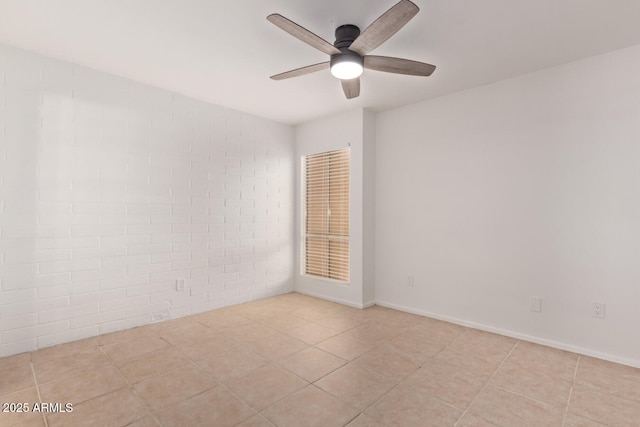 tiled spare room featuring baseboards and a ceiling fan