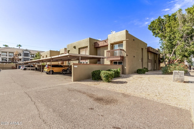 view of building exterior featuring covered parking and a residential view