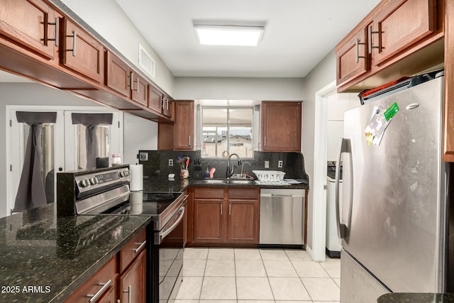 6426 W Lamar Rd, Glendale, AZ 85301 - kitchen featuring appliances with stainless steel finishes, a sink, washer and clothes dryer, tasteful backsplash, and light tile patterned floors