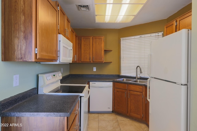 kitchen featuring sink, light tile patterned floors, and white appliances