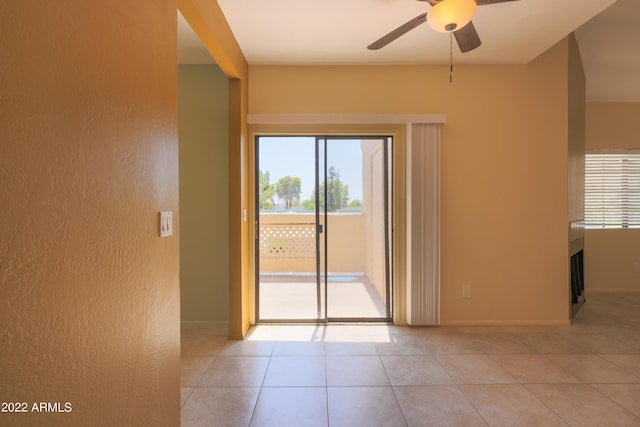 tiled spare room featuring ceiling fan