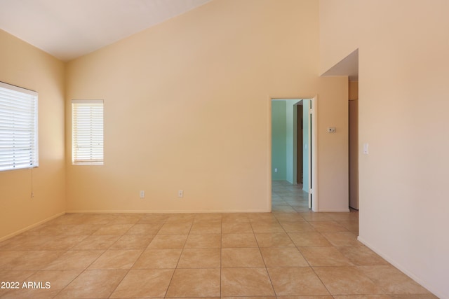 spare room with lofted ceiling and light tile patterned floors