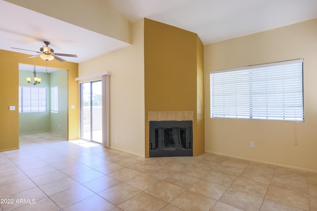 unfurnished living room featuring ceiling fan with notable chandelier and light tile patterned floors