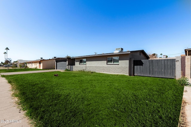 ranch-style house featuring a garage, a front yard, and cooling unit