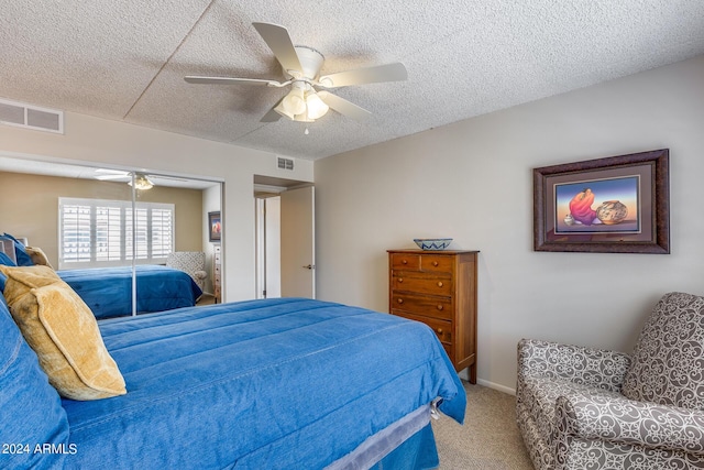 carpeted bedroom with a textured ceiling and ceiling fan