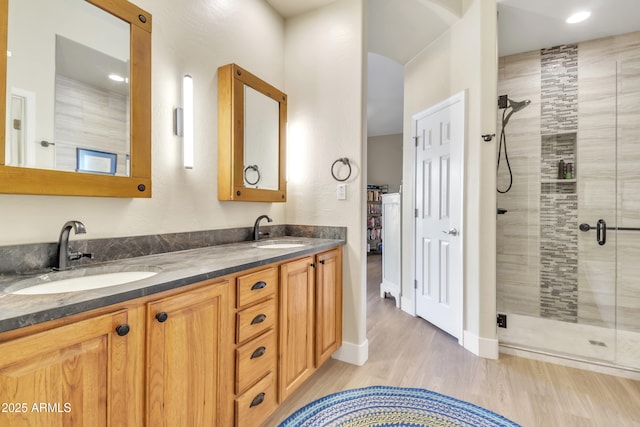 bathroom with wood-type flooring, vanity, and walk in shower