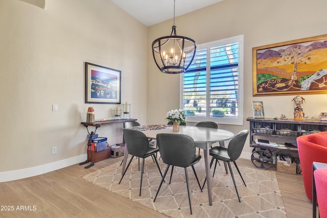 dining area with a notable chandelier and light hardwood / wood-style flooring