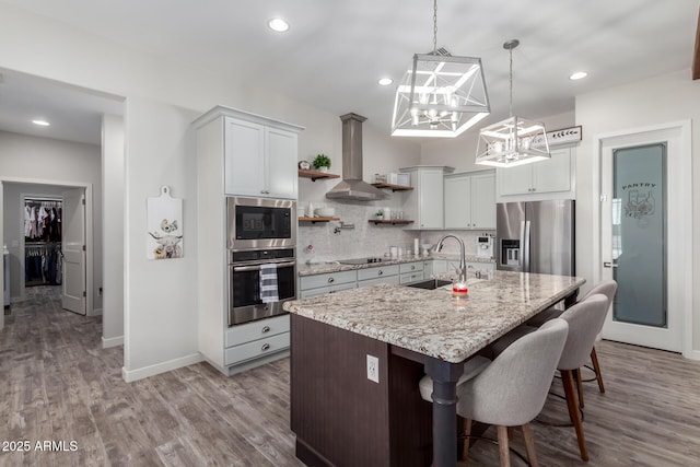 19436 W Windsor Ave, Buckeye, AZ 85396 - kitchen featuring appliances with stainless steel finishes, a sink, wall chimney range hood, a chandelier, and open shelves
