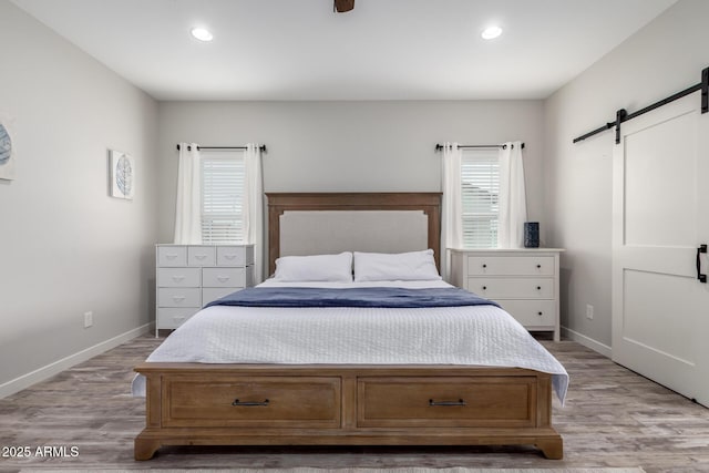 19436 W Windsor Ave, Buckeye, AZ 85396 - bedroom with a barn door, baseboards, recessed lighting, and light wood-style flooring