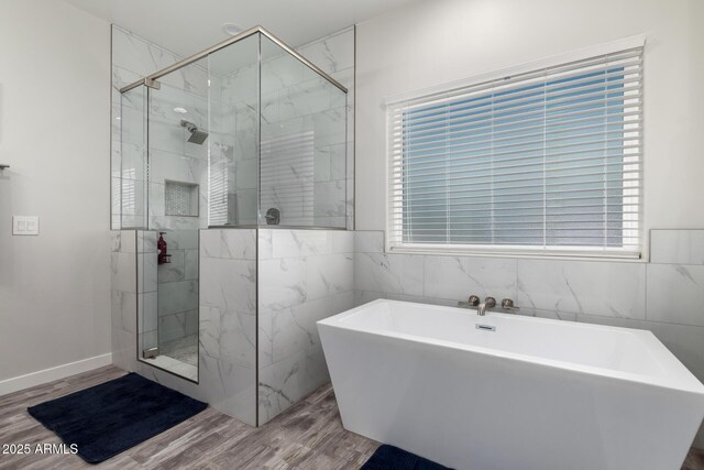 19436 W Windsor Ave, Buckeye, AZ 85396 - bathroom with a shower stall, a freestanding tub, wood finished floors, and tile walls