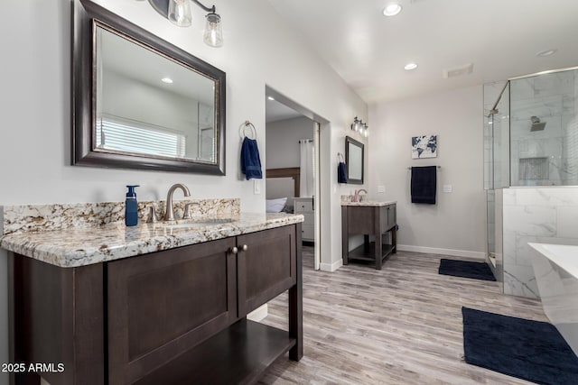19436 W Windsor Ave, Buckeye, AZ 85396 - full bath with a stall shower, baseboards, two vanities, wood finished floors, and recessed lighting