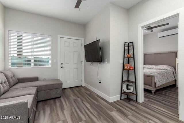 19436 W Windsor Ave, Buckeye, AZ 85396 - living room with ceiling fan, a wall mounted air conditioner, wood finished floors, and baseboards