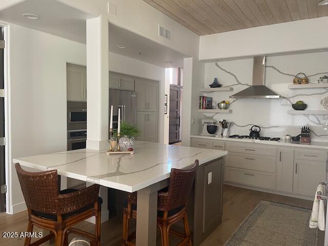 41576 N 107th Way, Scottsdale, AZ 85262 - kitchen featuring wall chimney exhaust hood, stainless steel appliances, open shelves, light stone counters, and dark wood-type flooring