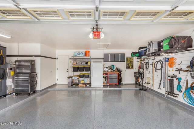 garage featuring a garage door opener, electric water heater, and white fridge