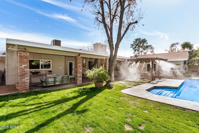 rear view of house with a yard and a patio area