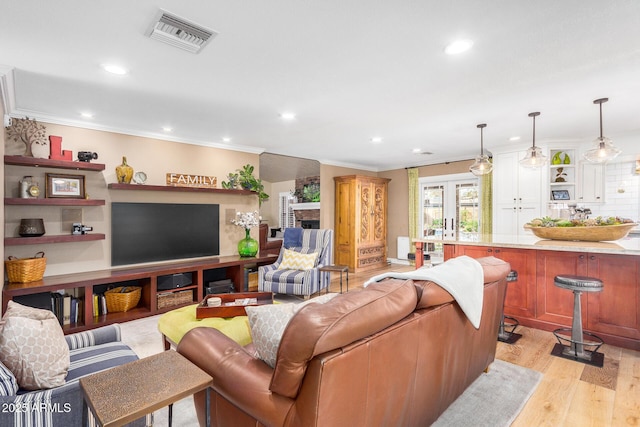 living room featuring light hardwood / wood-style flooring and crown molding